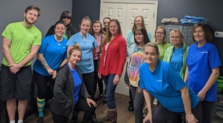 Franchise owner Christina Bowman with her team surrounding her in an office setting